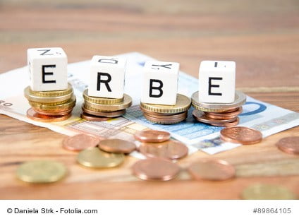 Würfel mit Schriftzug 'Erbe' auf Bargeld als Sinnbild für Wertgutachten von Immobilien im Erbfall